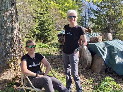 Martina und Elke lachend vor dem Holzstapel